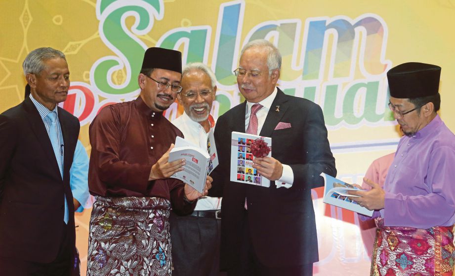Najib  berbual bersama  Pengarah Seranta Felda, Jabatan Perdana Menteri, Datuk Mohamad Khairudin Mohamad  (dua dari kiri) pada majlis Salam Perantauan Warga Felda 2107 di Putrajaya. 