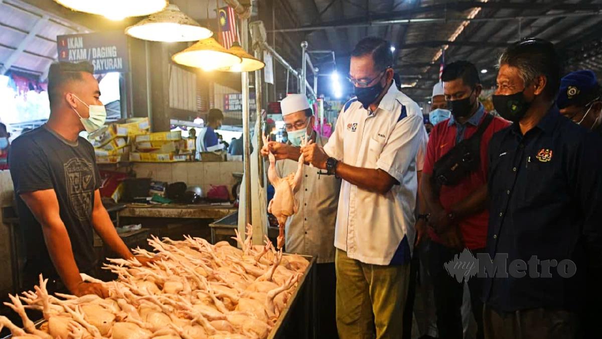 ROSOL (tengah) ketika meninjau bekalan ayam di Pasar Chabang Tiga, Kuala Terengganu, hari ini. FOTO Ghazali Kori.
