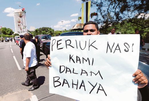 SEORANG pemandu teksi memegang sepanduk dalam bantahan di Padang Merbuk, semalam.