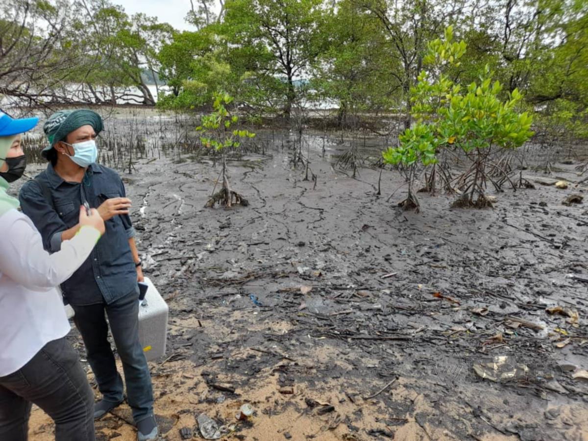 Dr Aldrie (kanan) berbincang dengan pegawai JAS mengenai tumpahan minyak di Hutan Simpan Kekal Tanjung Tuan, Port Dickson. FOTO HASSAN OMAR