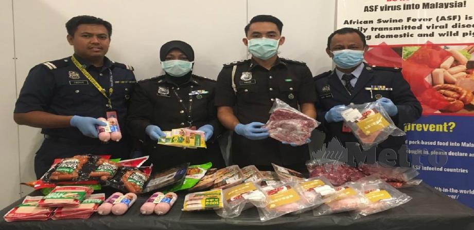 Pegawai MAQIS menunjukkan produk berasaskan babi dirampas mereka. FOTO Ihsan MAQIS