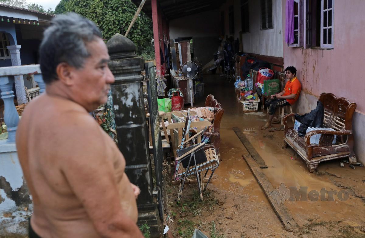 PENDUDUK melihat kemusnahan barangan selepas banjir surut di rumahnya di Kampung Bukit Gemuruh, Hulu Terengganu. FOTO Ghazali Kori.