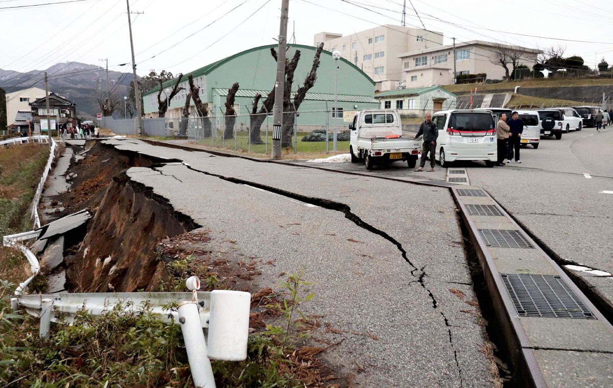PENDUDUK berdiri di kawasan runtuhan di bandar Wajima, wilayah Ishikawa selepas gempa bumi dengan magnitud 7.6. FOTO AFP. 