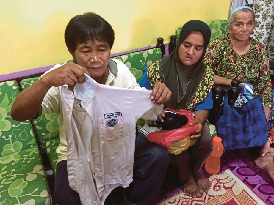  Surimin dan isteri, Rushedah  menunjukkan baju sekolah milik  Muhammad Faiz.