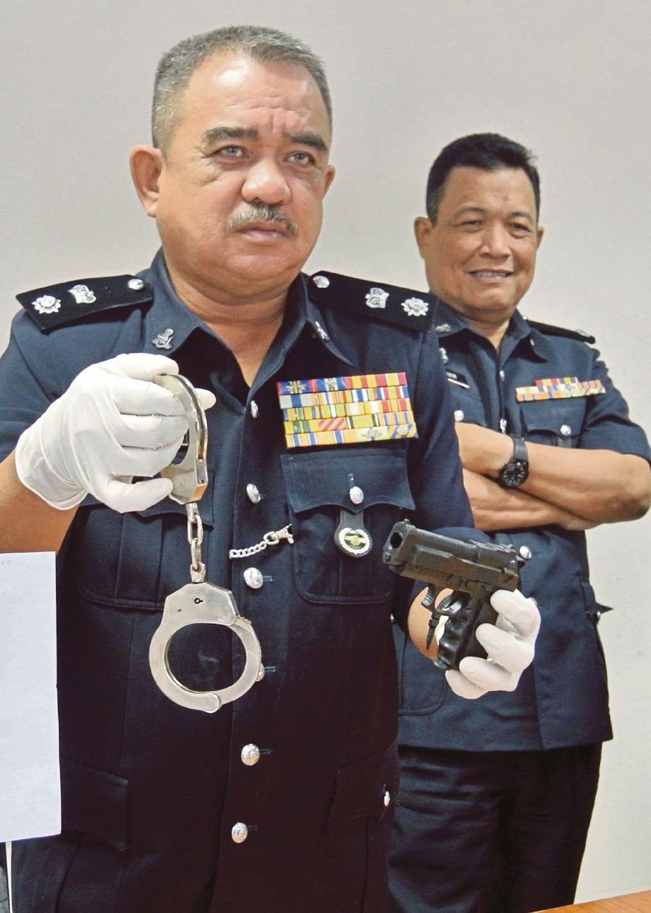  Noorzainy  menunjukkan pistol mainan dan gari yang digunakan lelaki menyamar pegawai polis. 