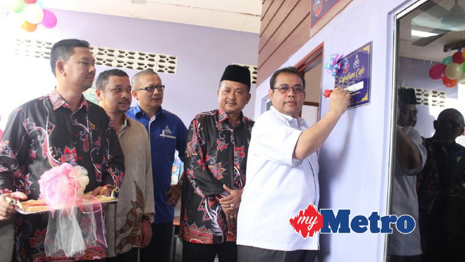 ABDUL Fattah menandatangani plak bagi perasmian Kiosk Koperasi Sekolah Menengah Kebangsaan Wakaf Bharu Tumpat. FOTO Nik Abdullah Nik Omar