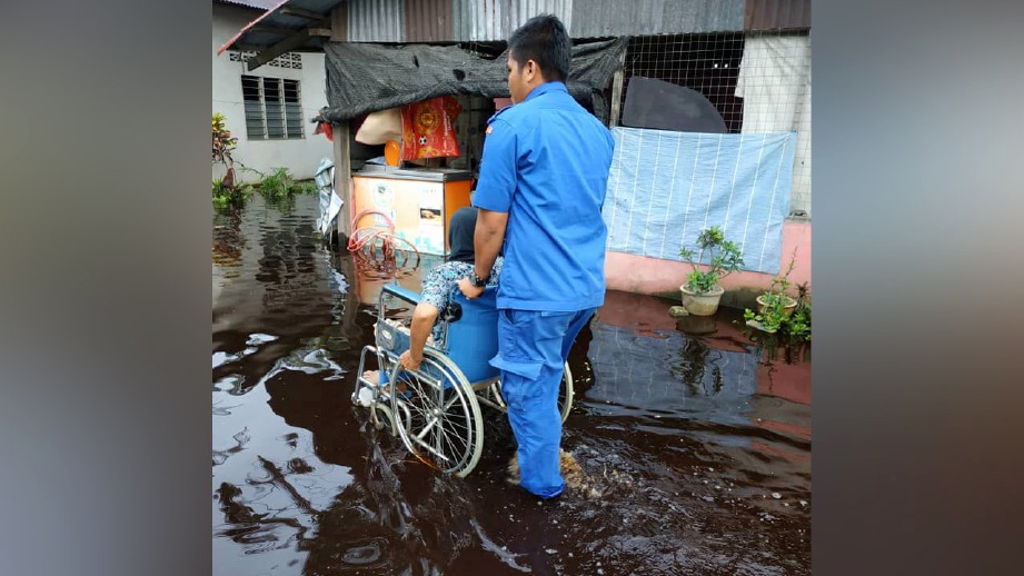ANGGOTA APM membantu mangsa banjir. FOTO ihsan APM