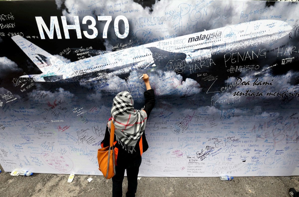 GAMBAR fail seorang pengunjung mengambil kesempatan menulis di atas kain rentang bagi memberi kata-kata semangat di atas kehilangan pesawat MH370. FOTO Arkib NSTP