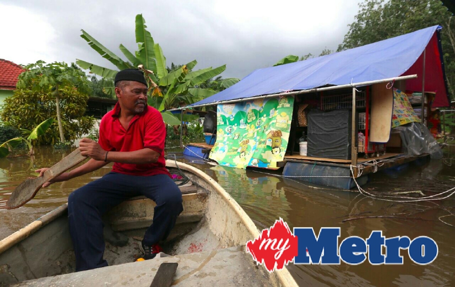 Penduduk, Abdul Manan Joraimi meninjau keadaan rakit yang digunakan untuk meletakkan perkakas rumah supaya tidak ditenggelami air akibat banjir di Kampung Jawa, Lenga, Muar. FOTO ADI SAFRI