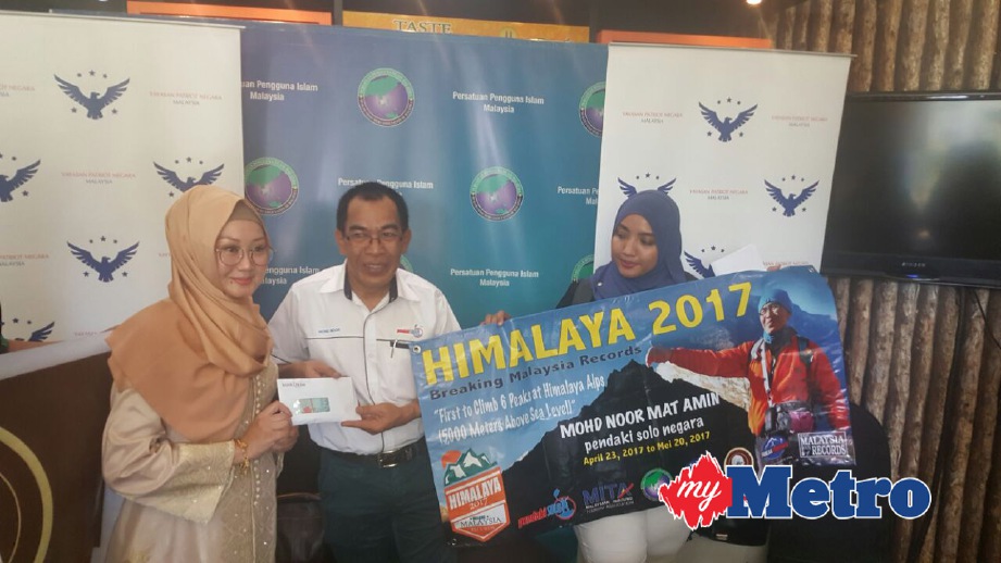 MOHD Noor (tengah) menerima sumbangan daripada YPNM. FOTO Yusmizal Dolah Aling
