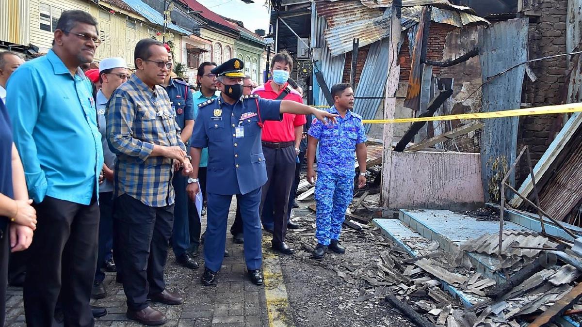 AHMAD Samsuri (depan, dua kiri) bersama Pengarah Jabatan Bomba dan Penyelamat Malaysia (JBPM) Terengganu Md Hilman Abd Rashid (depan, tiga kiri) di kawasan kebakaran. FOTO Ghazali Kori