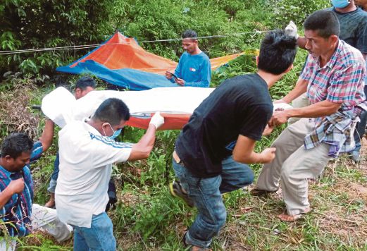 ANGGOTA polis dan penduduk kampung mengangkat mayat Jusoh  yang ditemui mati di dalam sebuah parit kering.