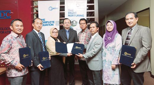 NORHALIM (empat dari kiri) bersama wakil syarikat selepas majlis menandatangani perjanjian di Universiti Putra Malaysia, semalam.