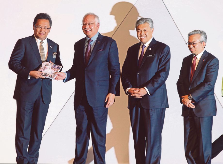 NAJIB  menyerahkan buku Halatuju Transformasi Ekonomi Bumiputera 2.0 kepada Menteri di Jabatan Perdana Menteri Datuk Seri Abdul Rahman Dahlan sambil disaksikan  Timbalan Perdana Menteri Datuk Seri Dr Ahmad Zahid Hamidi dan Husni (kanan).