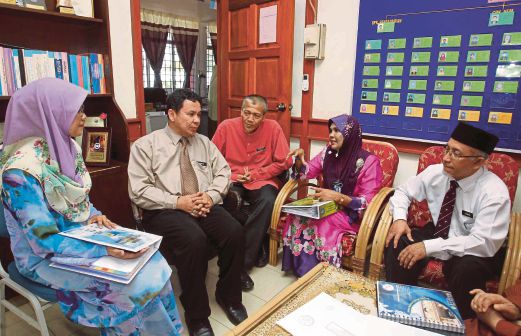 Ummal Salmah (dua kanan) berbincang dengan Guru Besar SK Ampang Pecah, Hassan Basri Ismail (dua  kiri).