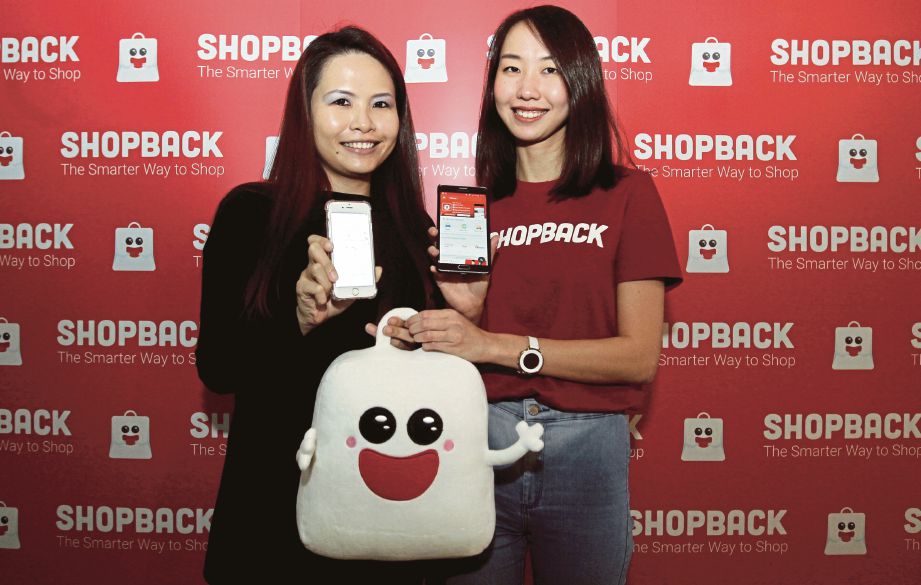 lai  (kanan) bersama Pengurus Pertumbuhan Pemasaran Kanan Uber Malaysia, Yan Ven Tee menunjukkan aplikasi ShopBack yang kini turut menyenaraikan Uber sebagai salah satu daripada perkhidmatan yang ditawarkan. 
