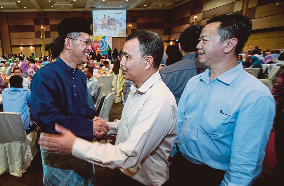 HASAN Azhari (kiri) beramah mesra dengan wakil syarikat yang hadir pada Sambutan Aidilfitri Invest Selangor. 