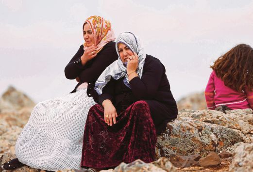Wanita Kurdis Turki memerhatikan pertempuran di Kobane di kawasan berhampiran lintasan sempadan Mursitpinar.