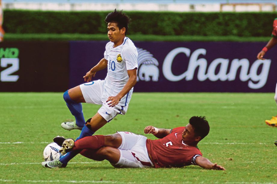 MUHAMMAD Akhyar Abdul Rashid (atas) diterjah pemain Indonesia. 