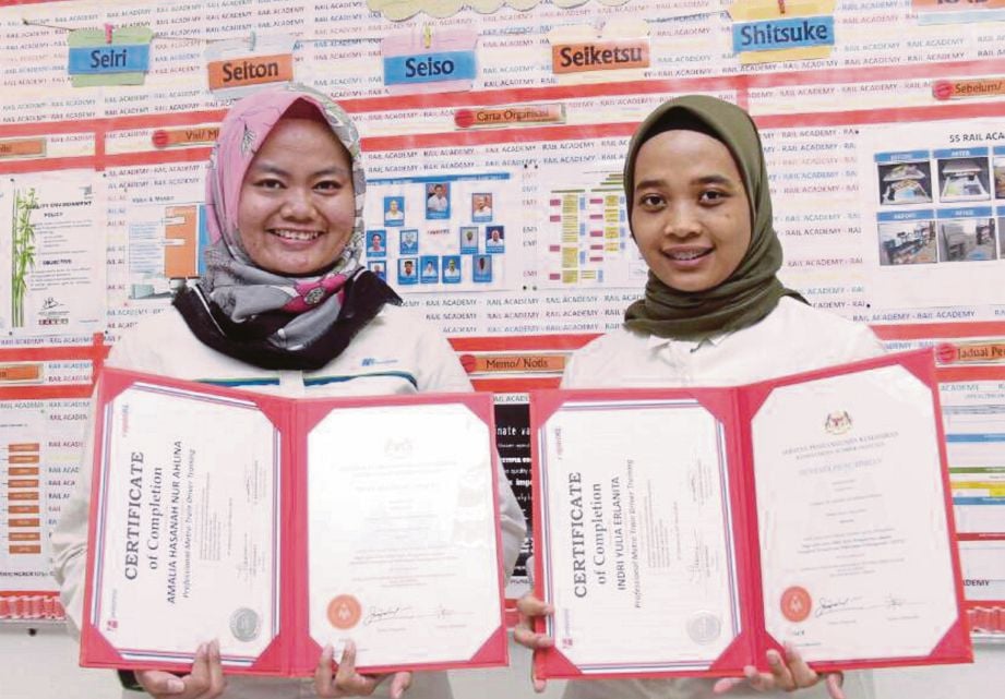 INDRI  Yulia (kanan) dan Amalia Hasanah  menunjukkan  sijil tamat latihan dengan Akademi Rel. 
