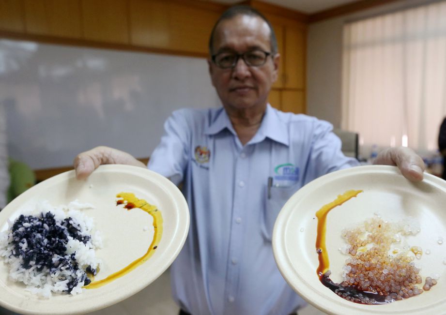 Abdul Rahim menunjukkan beras tulen  (kiri) dan plastik yang  dimasak selepas membuat ujian  awal.