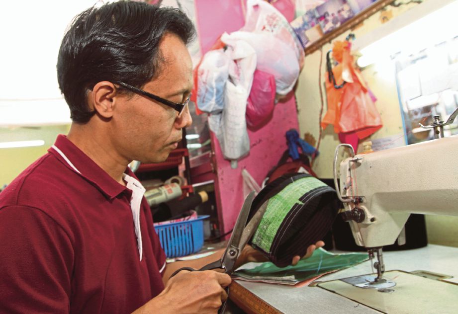  Mohd Nasrul menjahit songkok  di kedainya di Bazar Muhibah bandar Pekan.