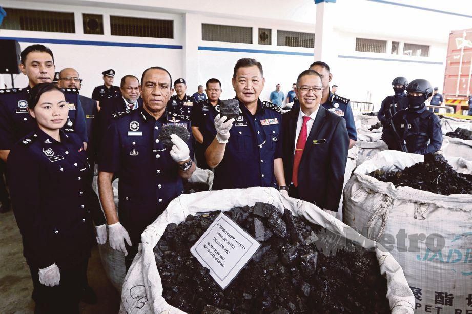 ABDUL Hamid (tengah) menunjukkan arang batu dicampur kokain yang dirampas. FOTO Mikail Ong