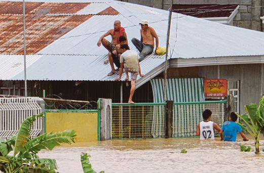 BEBERAPA penduduk di Santa Rosa, wilayah Neuva Ecija di utara Manila, terpaksa memanjat bumbung rumah mereka selepas banjir melanda kawasan itu, semalam. 
