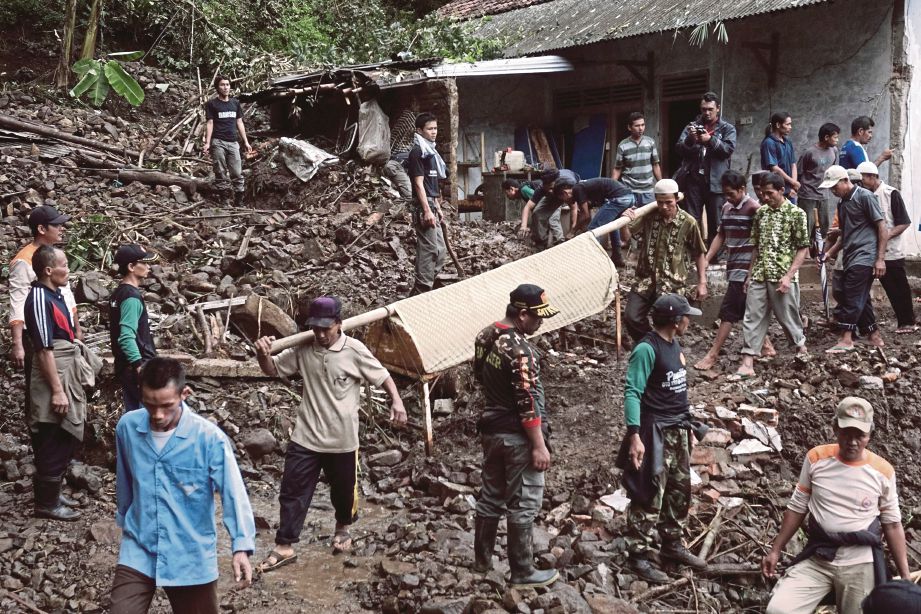 PENDUDUK kampung dan pasukan penyelamat mengusung mayat seorang mangsa tanah runtuh di Kampung Gumelem Kulon, Banjarnegara, Jawa Tengah, semalam.