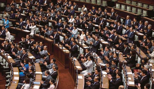 ANGGOTA Parlimen dari parti pemerintah menepuk tangan selepas rang undang-undang  diluluskan.