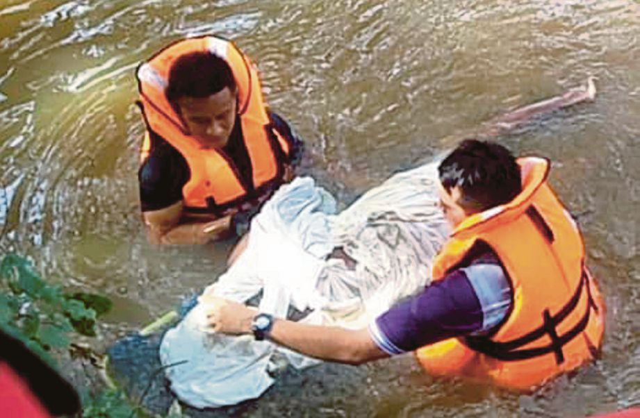  Anggota penyelamat     membawa naik mayat Nidzam   yang lemas di Sungai Kedah, semalam.  