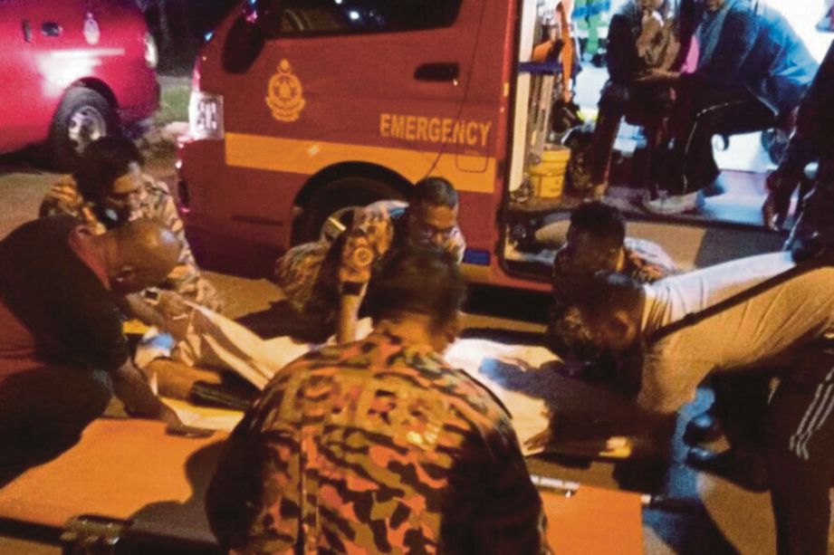 ANGGOTA bomba mengangkat mangsa yang lemas di  Kuala Manjung Point 5.