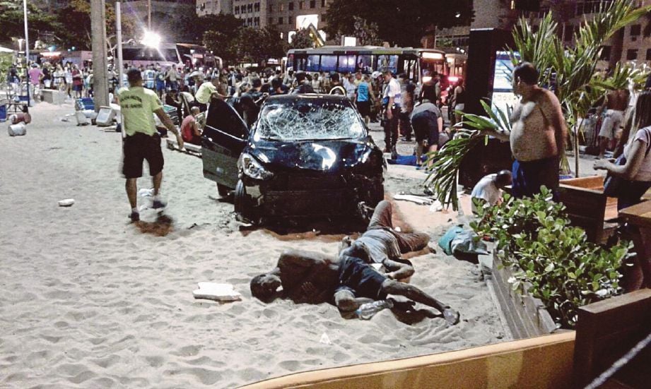 MANGSA yang cedera menunggu bantuan di hadapan kereta yang merempuh mereka di pantai Copacabana di Rio de Janeiro, Brazi kelmarin. - EPA