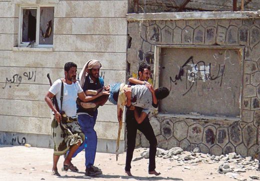 PEJUANG yang setia kepada Presiden Abed Rabbo mengusung rakan mereka yang cedera dalam pertempuran dengan pemberontak Houthi di Aden, semalam.  