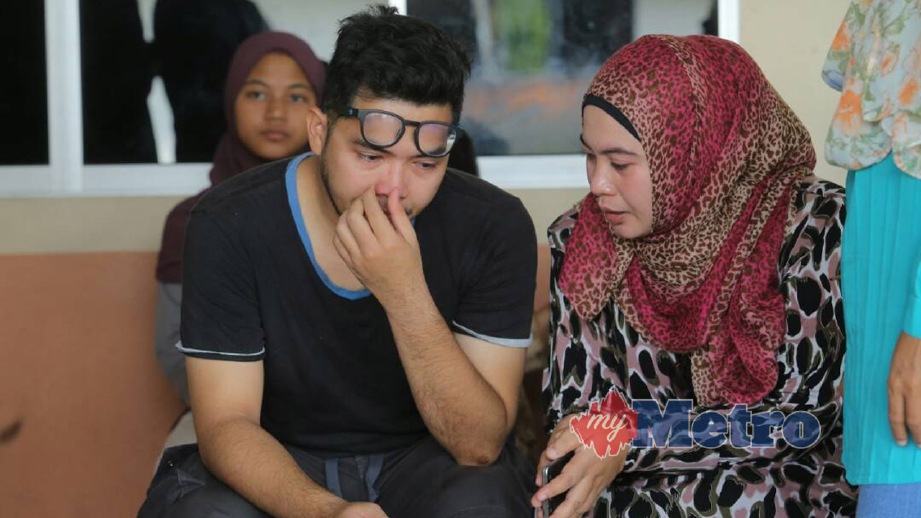 RAFIEZUL (kiri) ketika menunggu jenazah adiknya Rafiq yang terlibat dalam kemalangan. FOTO Abdullah Yusof