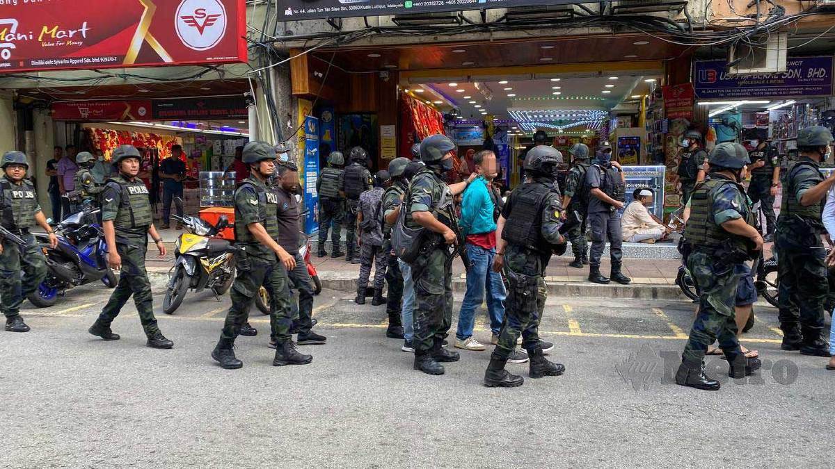 ANGGOTA dan pegawai polis ketika operasi di 'mini Dhaka' di Jalan Silang, Kuala Lumpur. FOTO Hafidzul Hilmi Mohd Noor