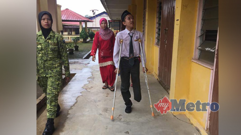 ABDUL Afza bersemangat untuk kembali ke sekolah ditemani ibunya, Siti Halimah Mohammad, 37, (baju merah) di SMK Rantau Panjang. FOTO ihsan The Thirdforce Rantau Panjang
