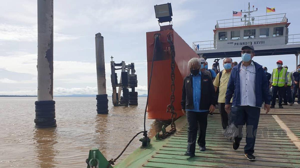 MENTERI Muda Pembangunan Pelabuhan dan Infrastruktur Sarawak, Datuk Julaihi Narawi (kanan) mengiringi James Jemut (kiri) melawat lokasi kenderaan terjunam ke dalam sungai di pangkalan feri Triso. FOTO Norsyazwani Nasri