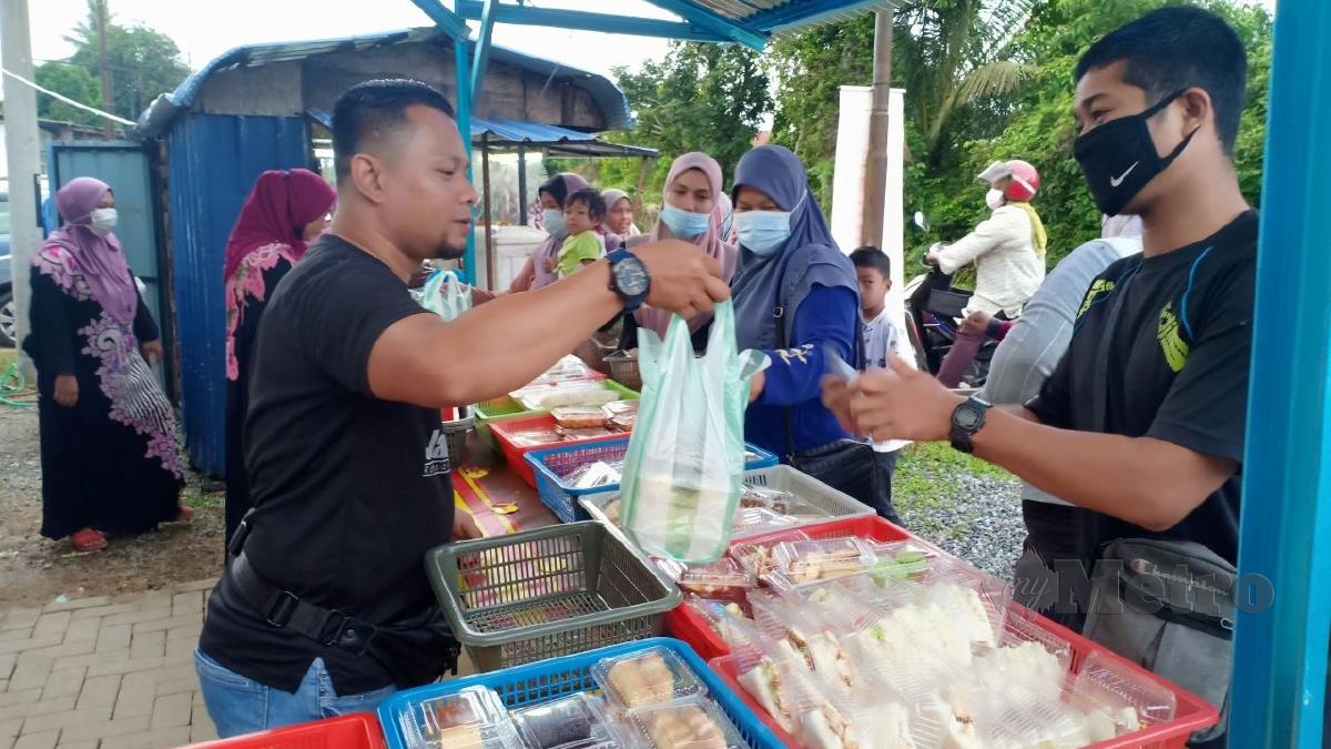 ORANG ramai memenuhi gerai makanan berharga RM1 di Kampung Tasik Padang Khabor. FOTO Ahmad Rabiul Zulkifli