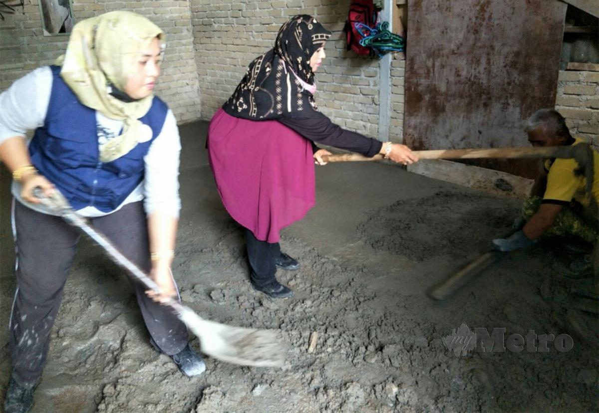 ANGGOTA Rela bersama Cakna Kasih Gua Musang membantu menyimen lantai rumah. FOTO Ramli Ibrahim