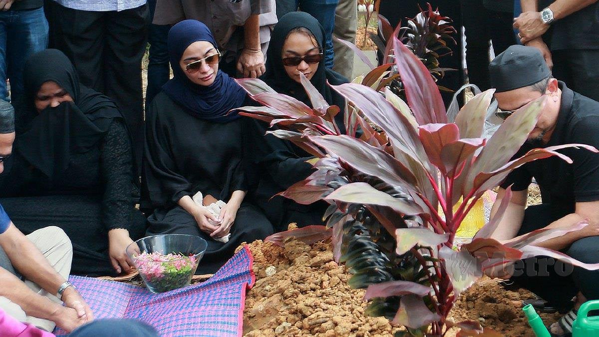 KILAFAIRY (dua kiri) di pusara ibunya, Rohana Jalil di Tanah Perkuburan Islam USJ22, Subang Jaya. FOTO Faiz Anuar