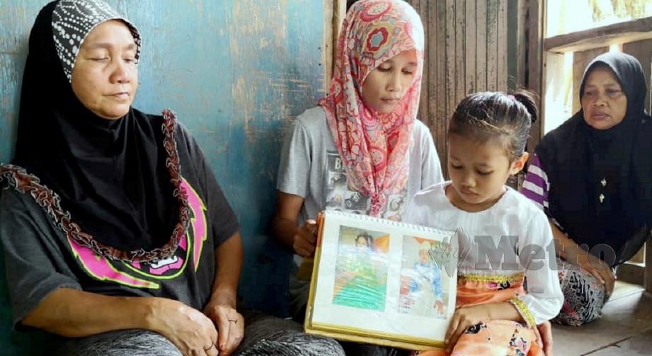 JANNEYANTI (tiga kiri) melihat gambar arwah bapanya, Jari Abdullah ketika ditemui di rumah mereka. FOTO Poliana Ronnie Sidom