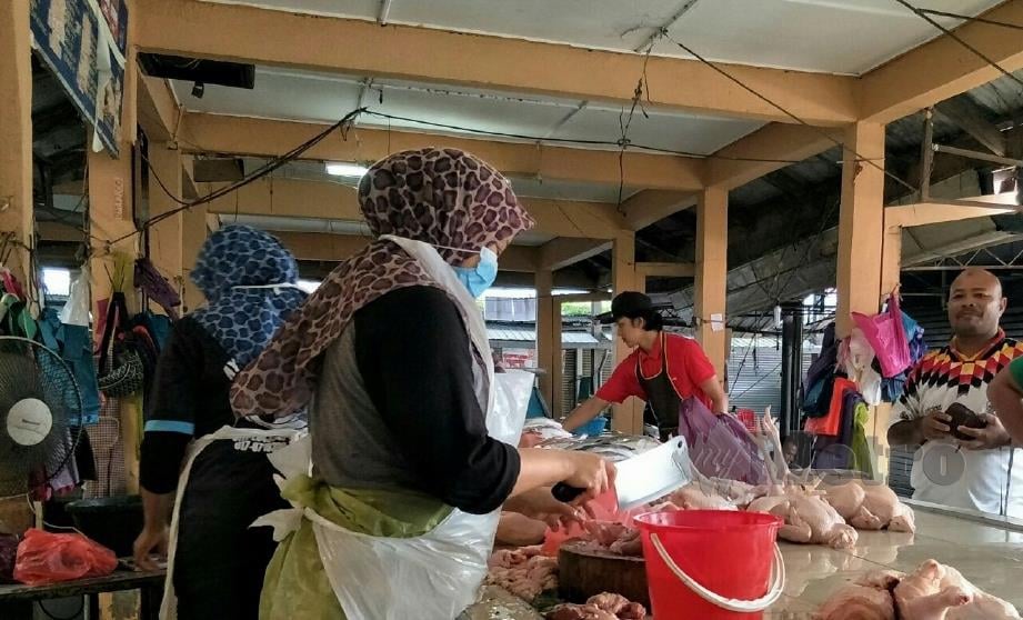 PENIAGA ayam segar dalam Pasar Besar Gua Musang akur dengan ketetapan harga RM7.50 sekilogram. FOTO Ramli Ibrahim