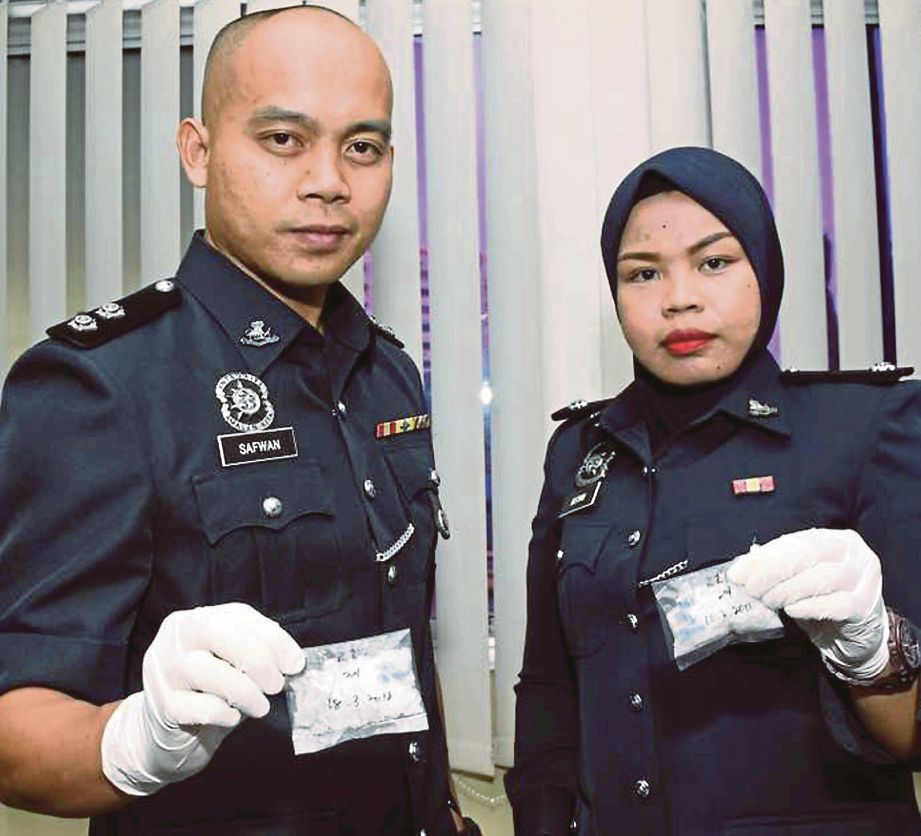   DUA pegawai polis menunjukkan dua bungkusan berisi dadah yang dirampas di Inanam dan Manggatal  pada sidang media di IPD Kota Kinabalu.  