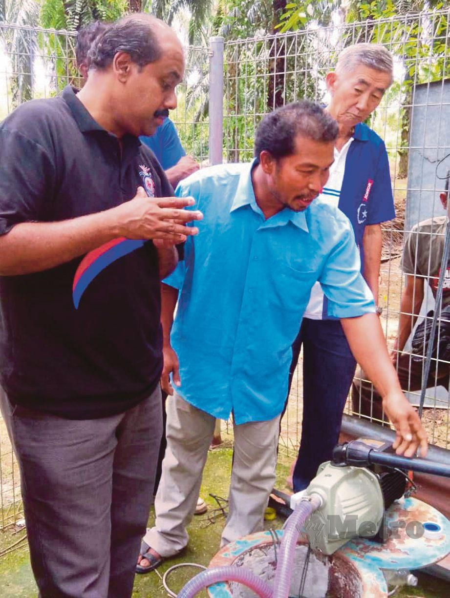 PIEE (kanan) menunjukkan kepada Vidyananthan (kiri) pam air yang dibeli hasil kutipan penduduk. FOTO Mohd Azren Jamaludin