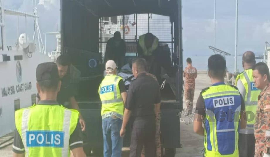 Mayat nelayan yang ditemui dimasukkan ke dalam kenderaan polis untuk dibawa ke hospital. FOTO Ihsan APMM