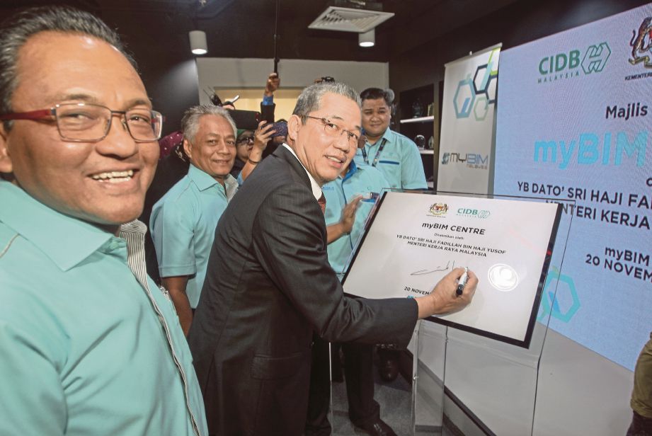 FADILLAH diiringi Ketua Eksekutif CIDB,  Datuk Asri Abdul Hamid (kiri)    merasmikan Pusat myBIM di Kuala Lumpur, semalam.