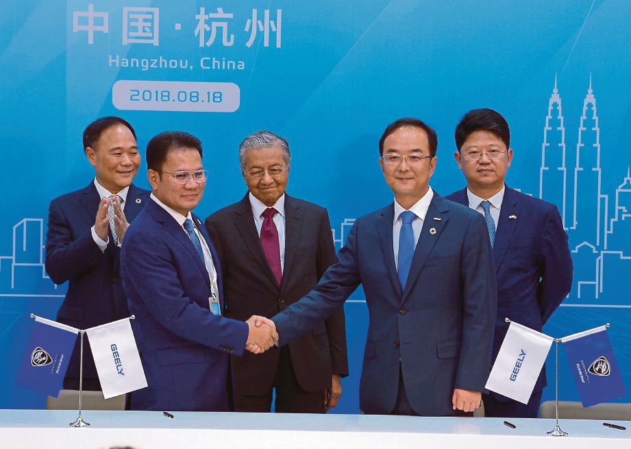 DR Mahathir  menyaksikan majlis perjanjian persefahaman antara  Syed Faisal (dua dari kiri) dengan Presiden Kumpulan Zhejiang Geely Holding, An Conghui  ketika  membuat lawatan kerja lima hari ke China.