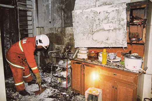 ANGGOTA bomba memeriksa dapur rumah mangsa yang terbakar.