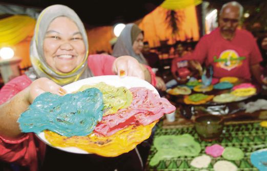 NUR Syuhaila Zulkefli menunjukkan roti canai warna-warni Aidilfitri yang menjadi juadah Rumah Terbuka Aidilfitri di Kompleks Japerun Rim, Bandar Jasin.